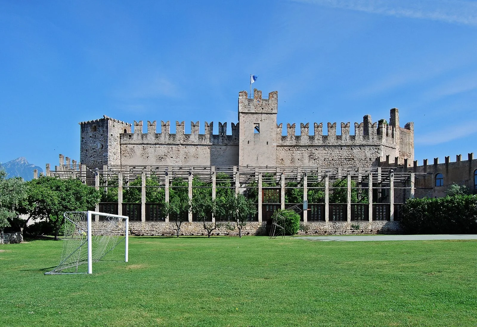 Il castello scaligero di Torri del Benaco con le mura merlate e la limonaia in primo piano