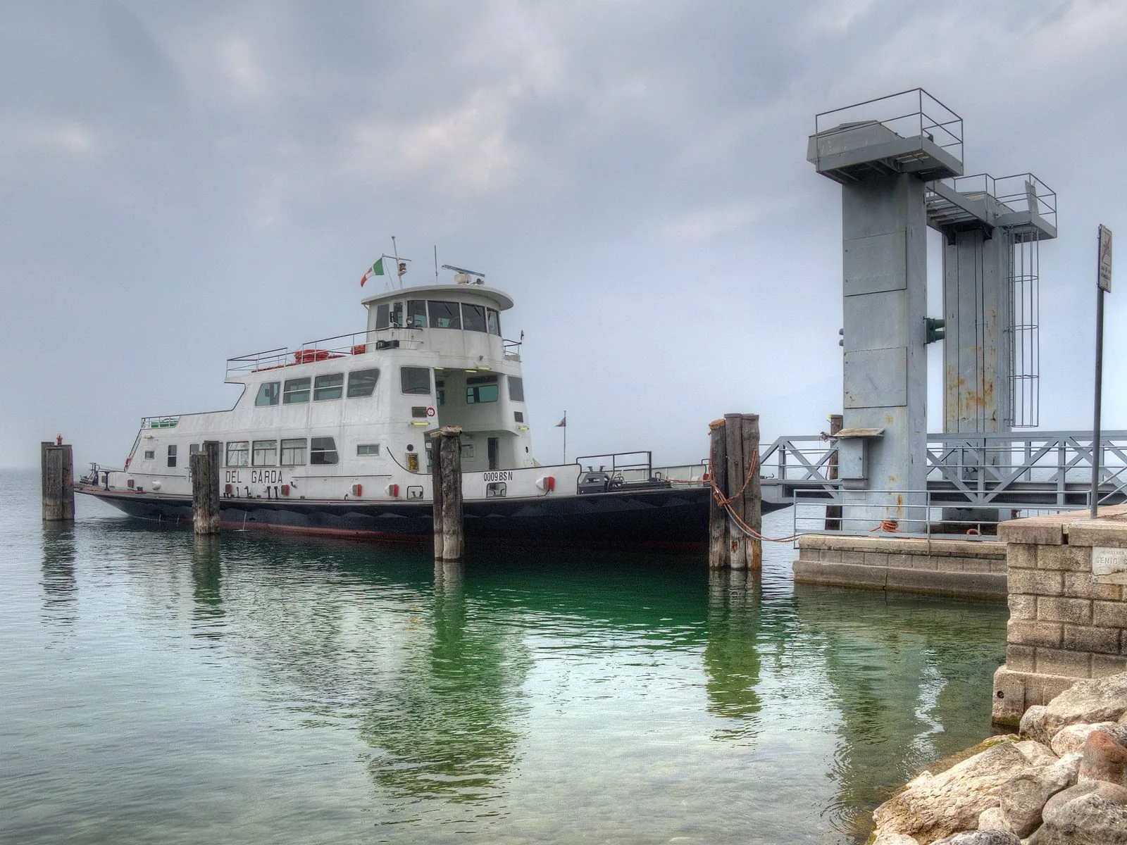 Il traghetto ormeggiato all'imbarcadero di Torri del Benaco, con l'acqua verde del lago